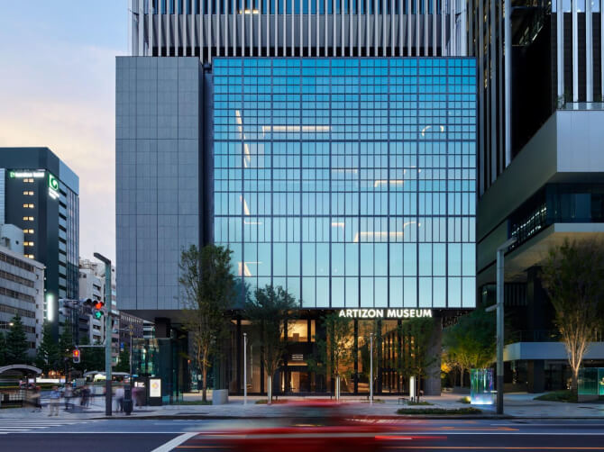 大きなガラス張りのミュージアムタワー京橋の外観。正面中央に「ARTIZON MUSEUM」の文字が見え、都市の街並みに溶け込むように建っている。