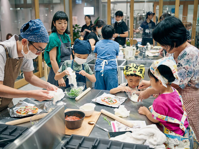 団地キッチンで子どもと大人が一緒に料理をしている様子。
