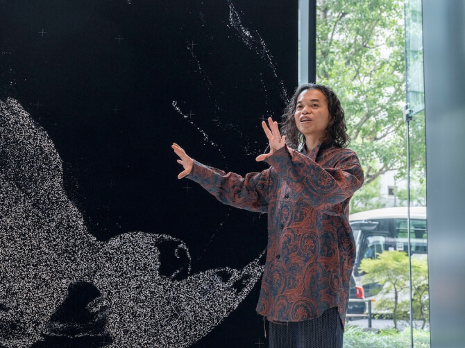 《WINDOWS》の前に立ち、作品のコンセプトについて身振りを交えて語る古舘健氏。