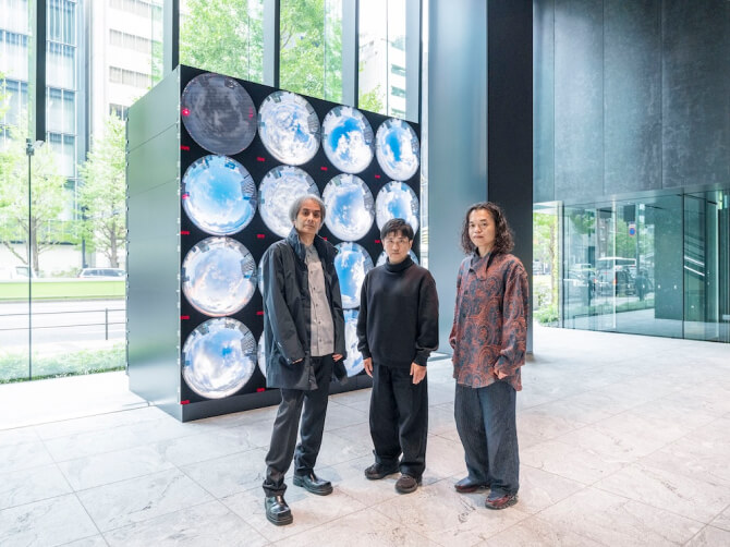 《WINDOWS》の前で、左から高谷史郎氏、濱哲史氏、古舘健氏が真剣な表情で並んで立つ写真。