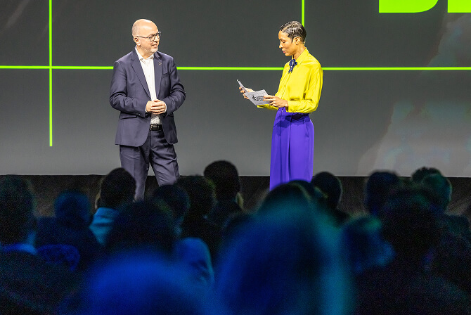 German Design Award 2026の授賞式で、司会者と審査員が壇上で話している様子。