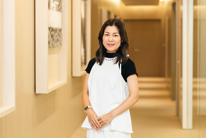 廊下でポーズをとる上田杏菜氏。