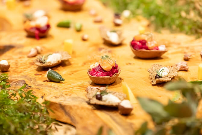 アボリジナル・アート展をテーマにしたイベントで提供された、木製ボードに並ぶ色鮮やかなインスパイア・フードの前菜。イベントレポート記事「オフィスビルに開かれた、アボリジナル・アートと五感の交差点」のサムネイル。