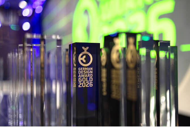 German Design Award 2026 Goldのトロフィーが並んでいる写真。「ミュージアムタワー京橋が手がけるプロジェクト「WORK with ART」の公式Webサイトが、German Design Award 2026金賞を受賞」のサムネイル。