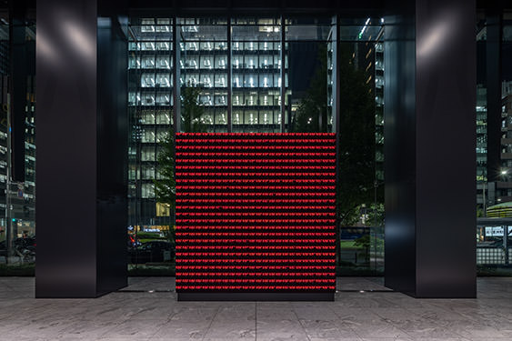 The work “WINDOWS” displayed at the entrance on the first floor of Museum Tower Kyobashi. A view of the LED display with neat rows of red text.