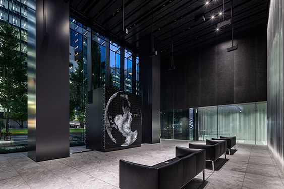 “WINDOWS” installed in the lobby space on the first floor of Museum Tower Kyobashi. The composition of the LED screen can be seen through the chairs.