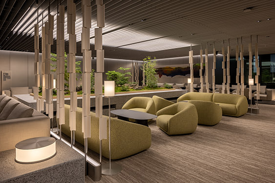 Soft lighting and organic furniture harmonize in the spatial design of the Museum Tower Kyobashi's 3rd floor office lounge.