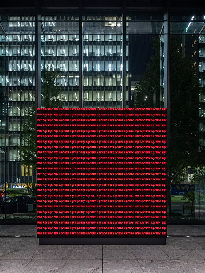 The work “WINDOWS” displayed at the entrance on the first floor of Museum Tower Kyobashi. A view of the LED display with neat rows of red text.